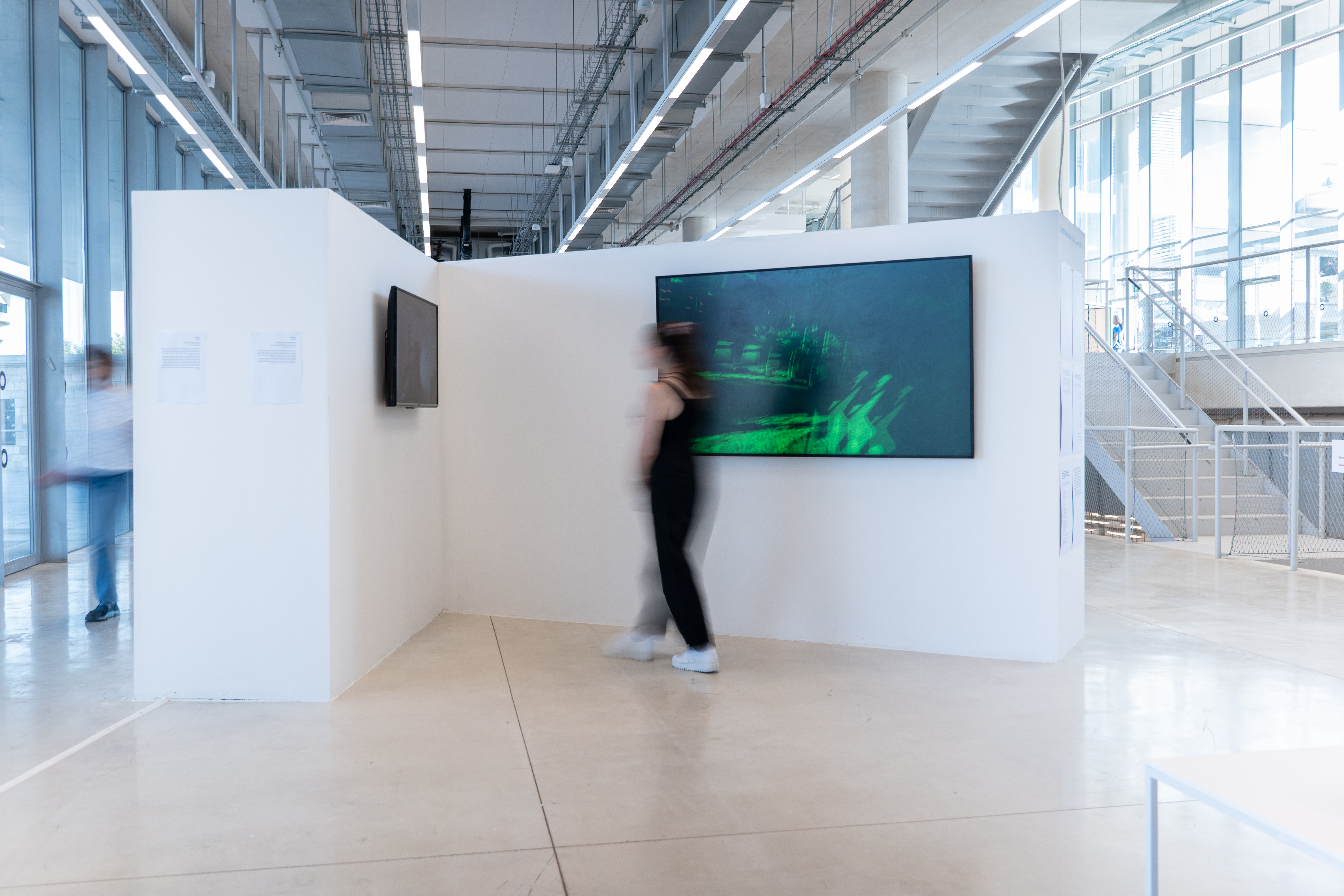 Gallery view — visitor passing the green VR screen